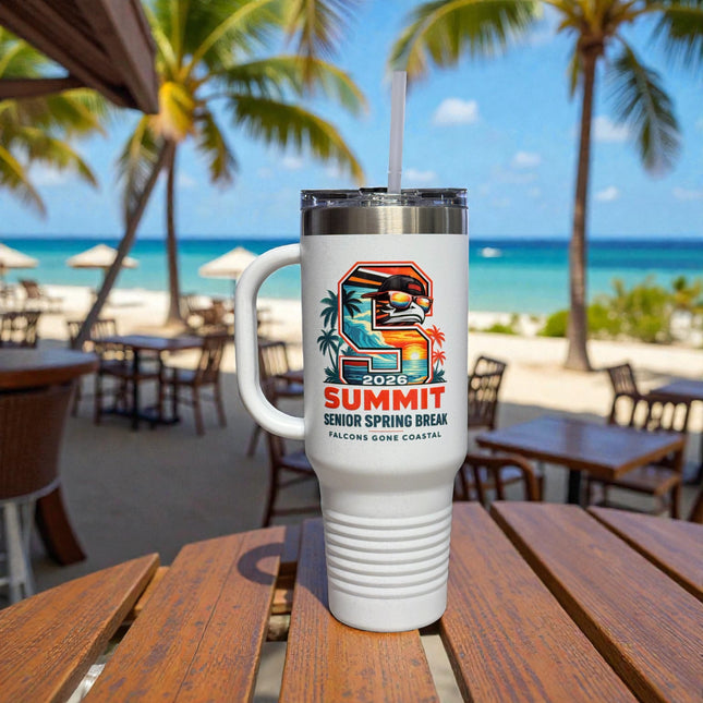 White tumbler with a colorful design on a wooden table at a beachside cafe.